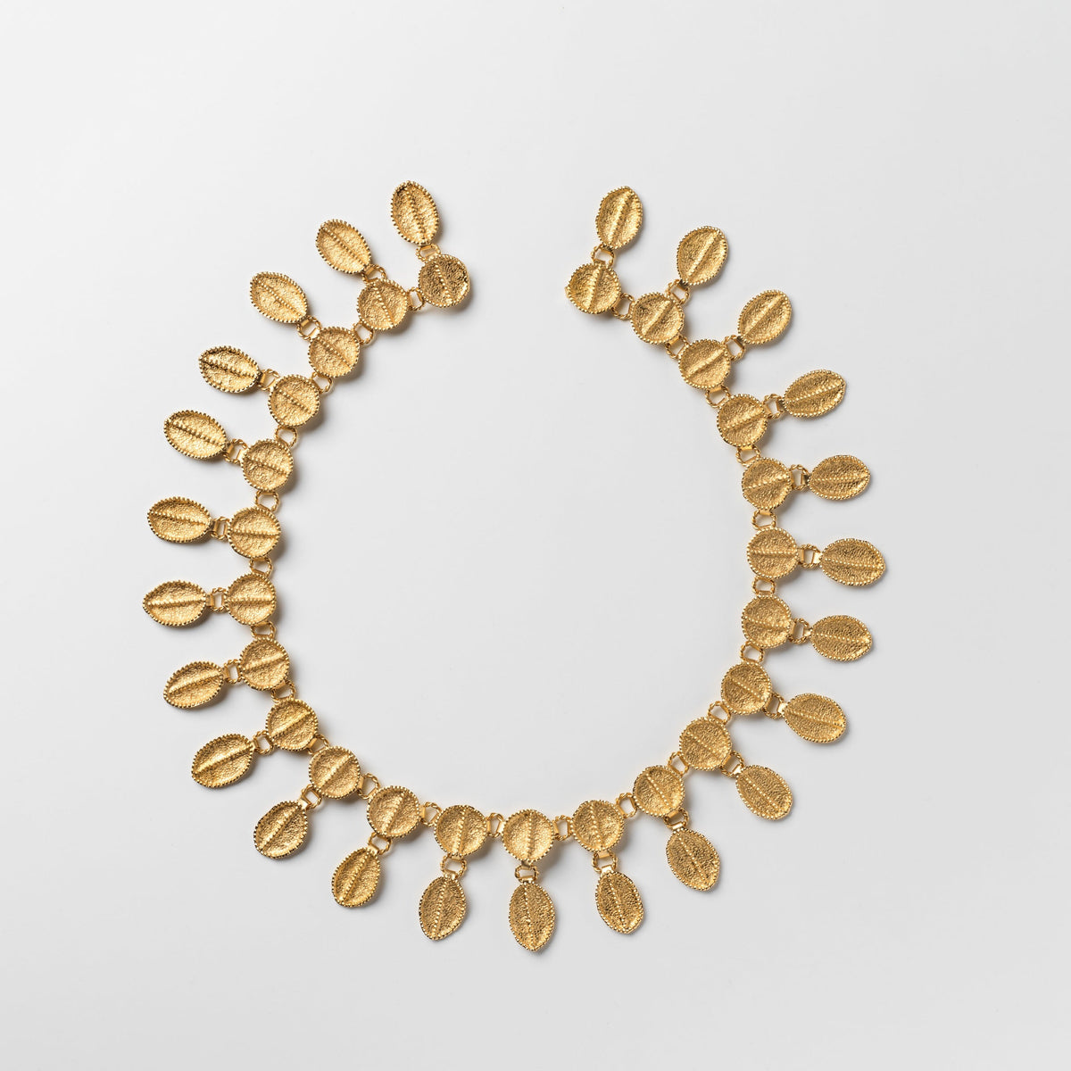 Gold necklace on a light gray background