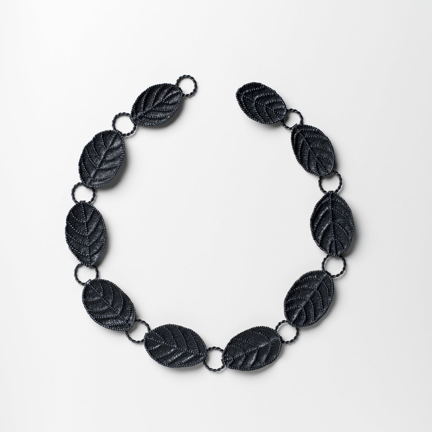 Black leaf-shaped necklace on a white background