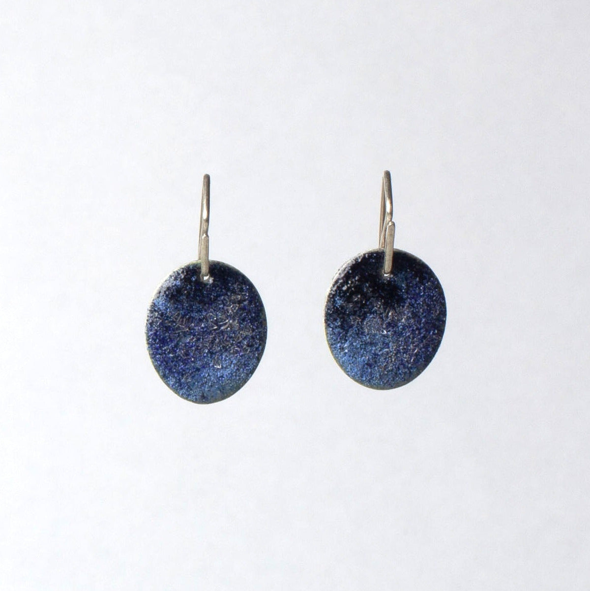 Pair of blue round earrings on a white background