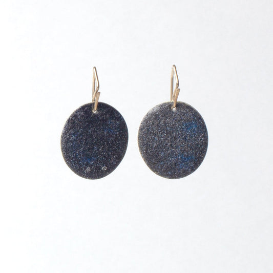 Pair of round earrings with a blue speckled texture on a white background