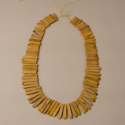 Necklace made of yellow wooden beads on a beige background