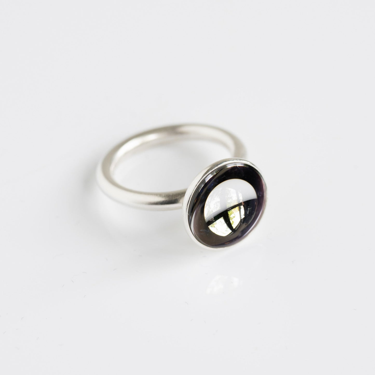 Silver ring with a black gemstone on a white background