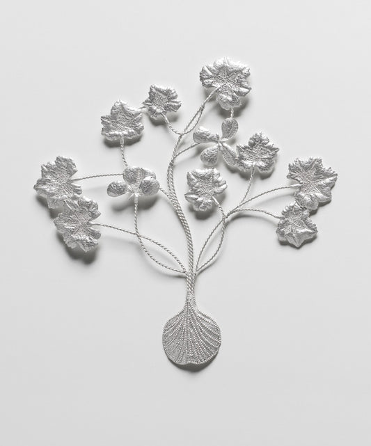 Silver floral brooch on a light gray background