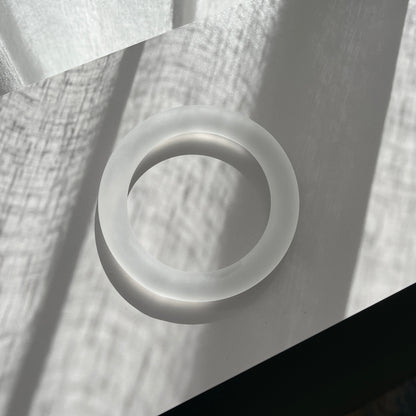 white glass bangle on a grey shelf