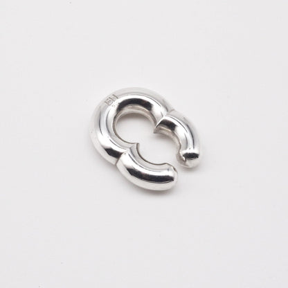 Silver earring on a light gray background