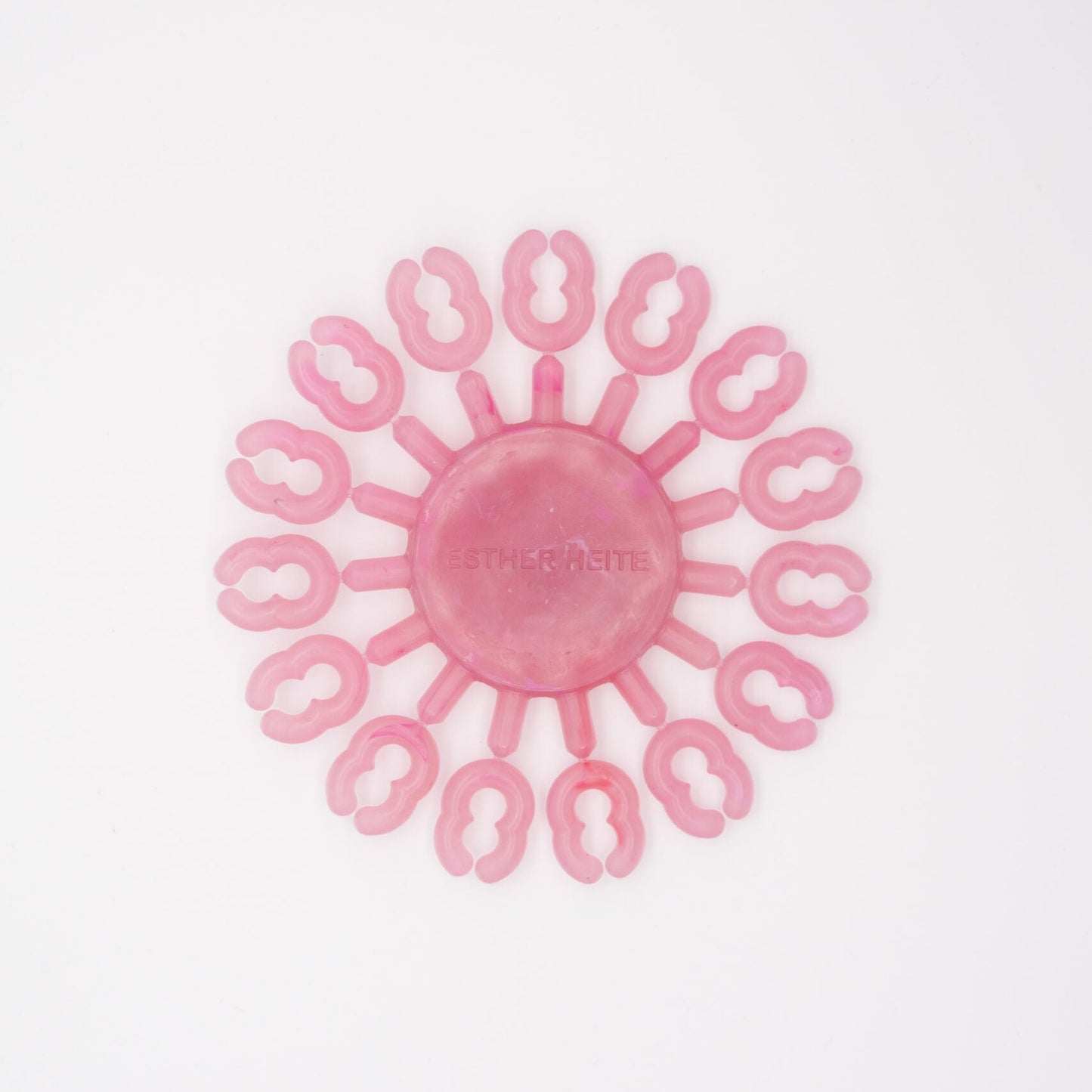 Pink silicone tool with circular design on a white background