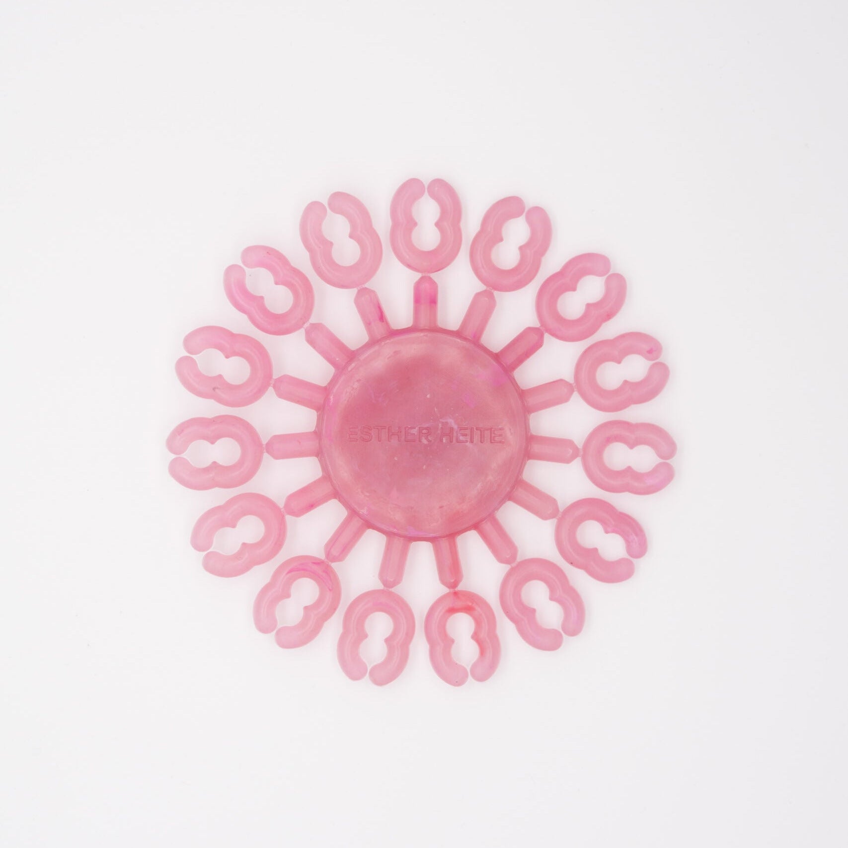 Pink silicone tool with circular design on a white background