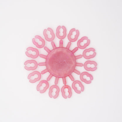 Pink silicone tool with circular design on a white background