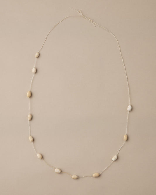 Necklace with small beige beads on a beige background