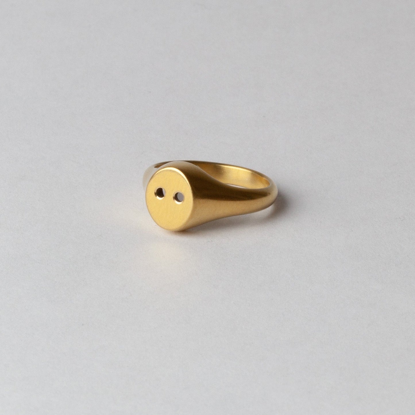 Gold ring on a light gray background