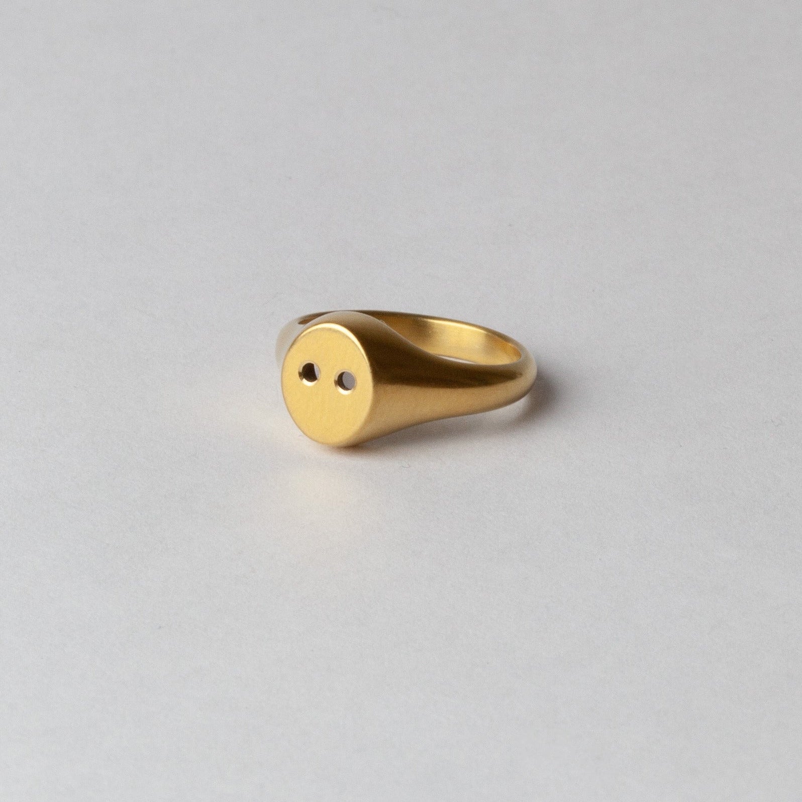 Gold ring on a light gray background