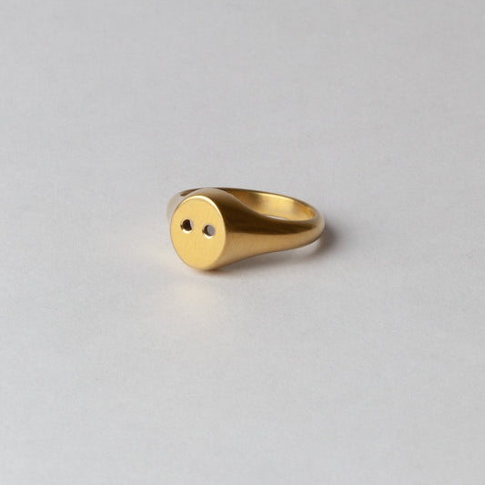 Gold ring on a light gray background