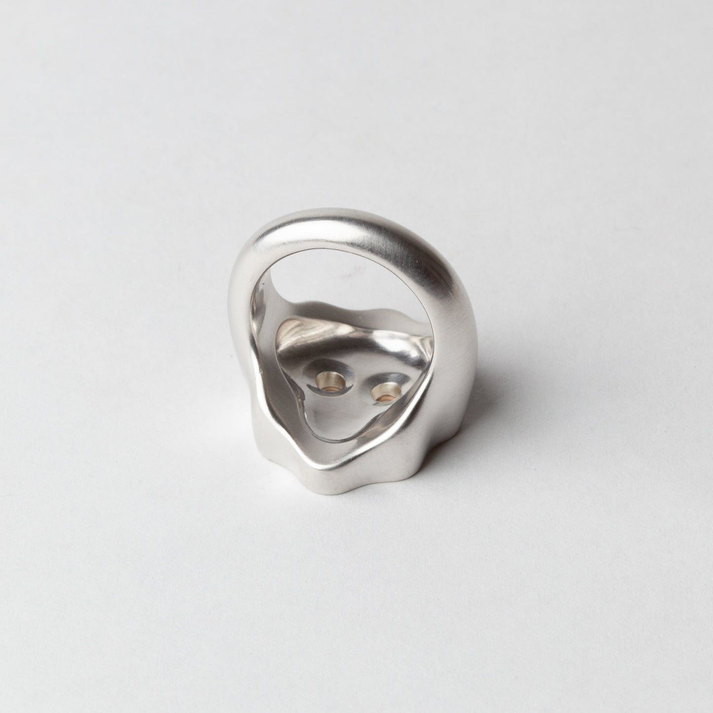 Silver ring with a unique design on a light gray background