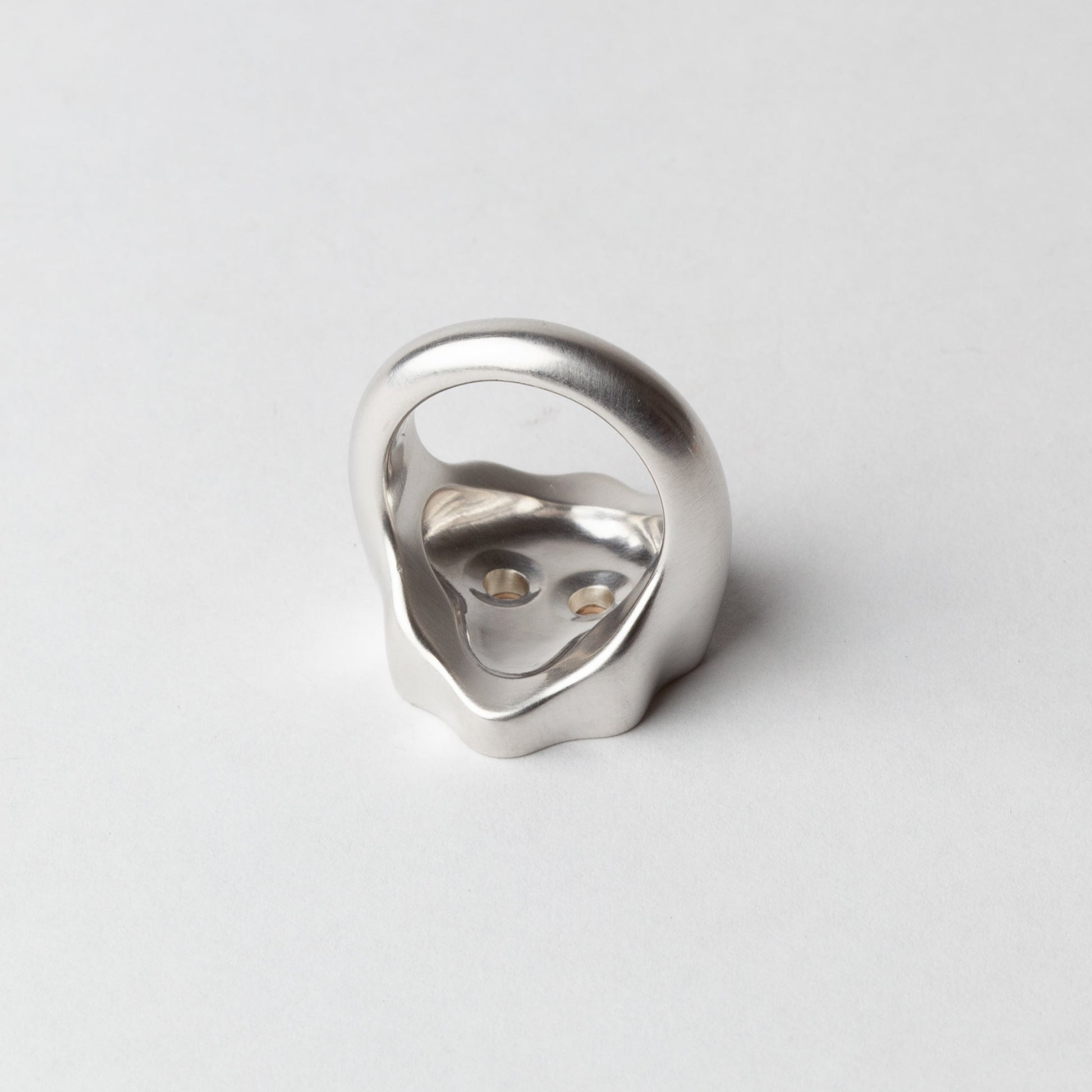 Silver ring with a unique design on a light gray background