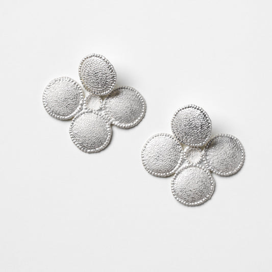 Pair of silver earrings on a light gray background