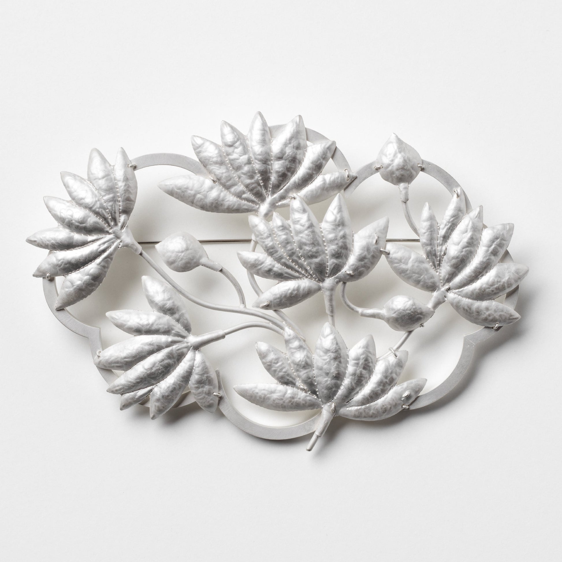 Decorative metal wall art with leaf designs on a white background