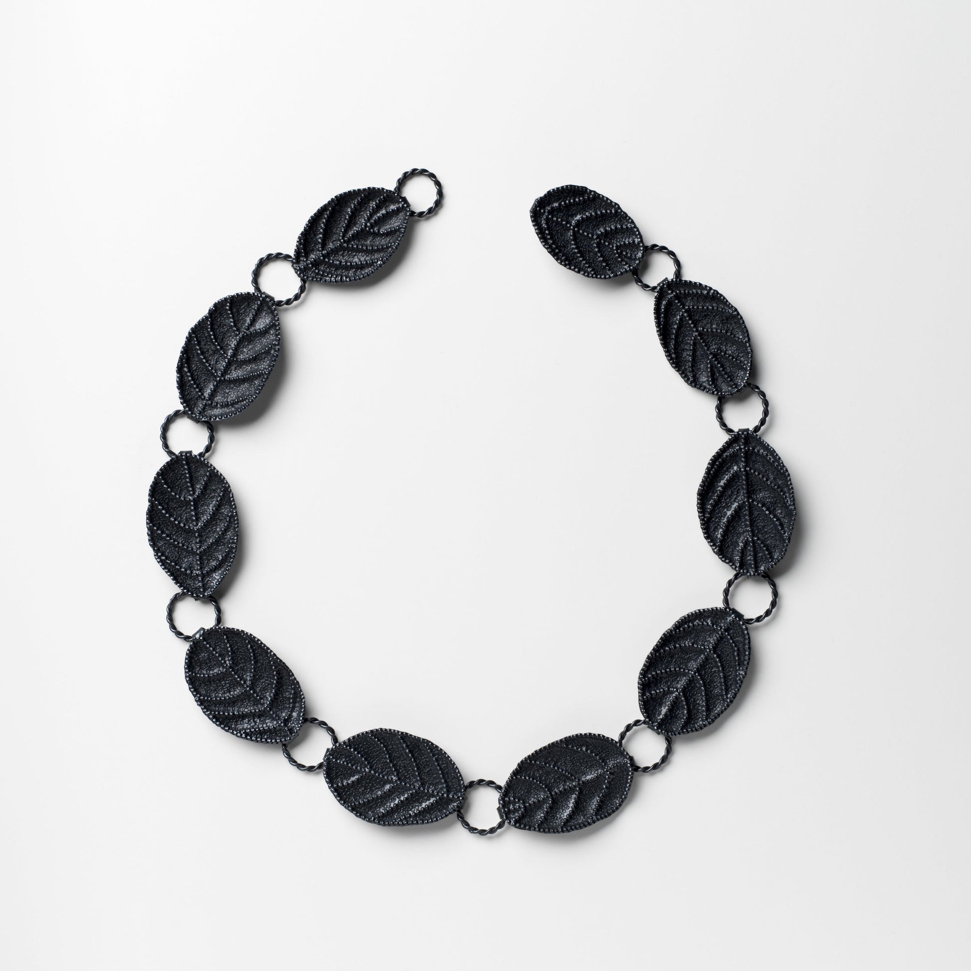 Black leaf-shaped necklace on a white background
