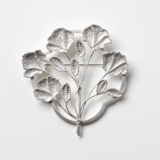 Silver leaf-shaped wall art on a light gray background
