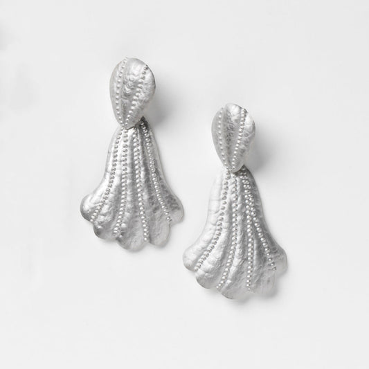 Silver tassel earrings on a light gray background