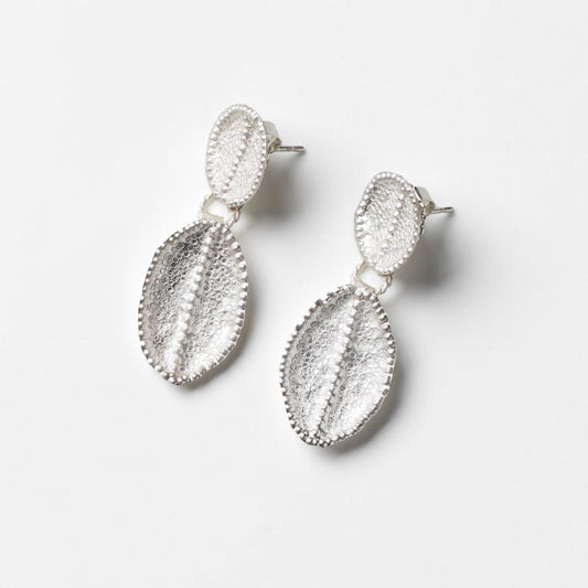 Pair of silver textured earrings on a white background