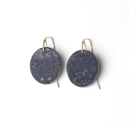 Blue black enamel earrings with gold hooks on a white background