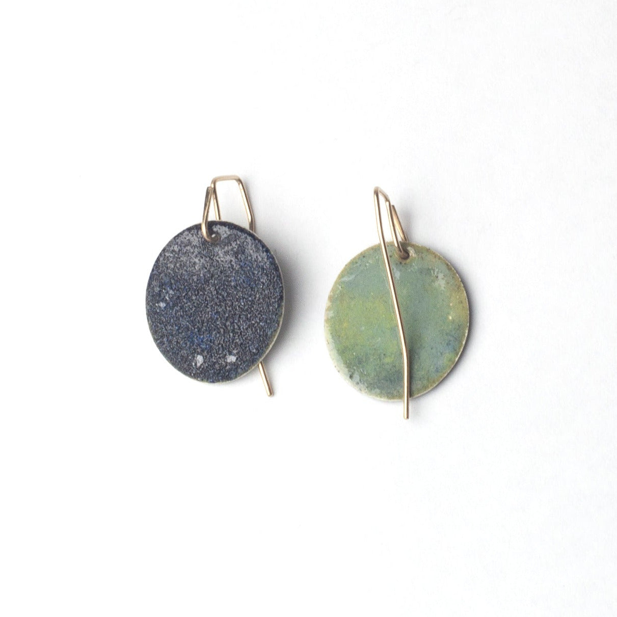 Two round earrings with gold accents on a white background
