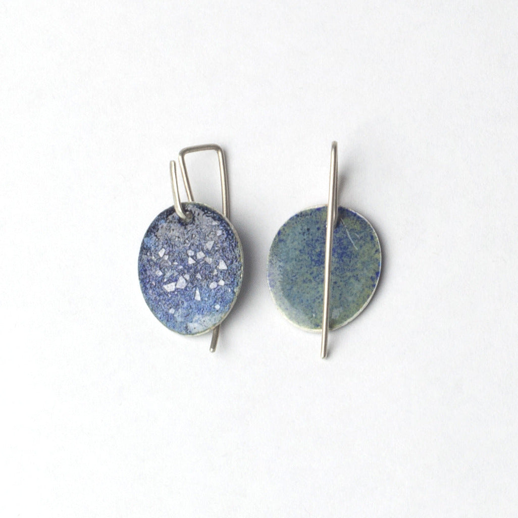 Pair of round earrings with blue and silver design on a white background