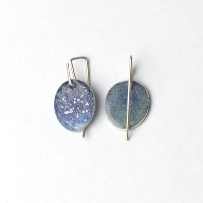 Pair of round earrings with blue and silver design on a white background