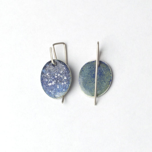 Pair of round earrings with blue and silver design on a white background