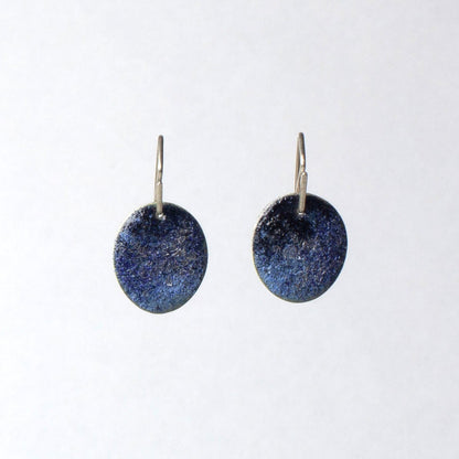 Pair of blue round earrings on a white background