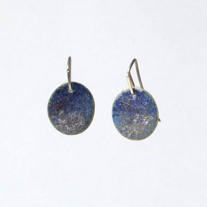 Pair of round earrings with blue and silver disc design on a white background